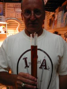 Steve Close holds hydrometer reading of our 50 proof Gnarly Wine final gravity - 1.062!